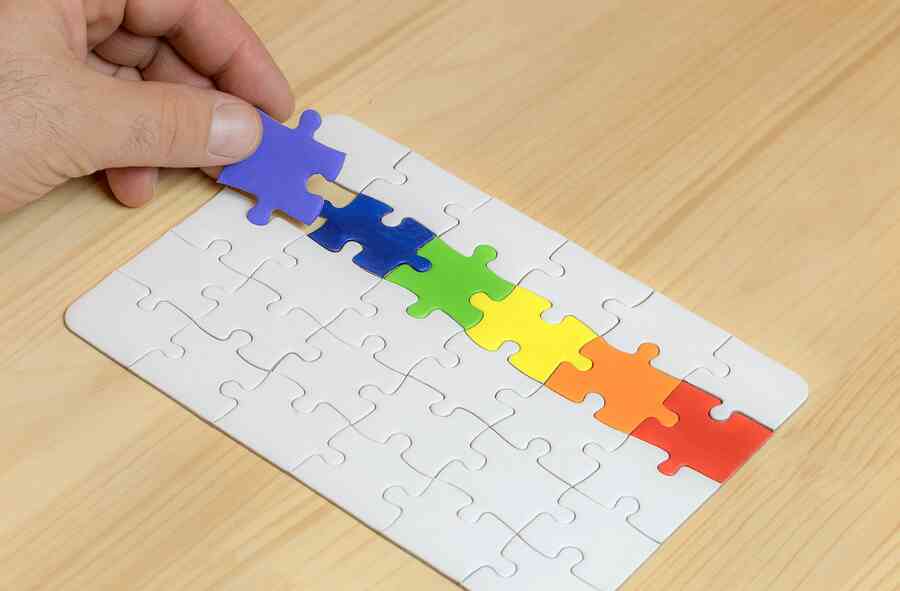 Person holding a puzzle with rainbow colors.