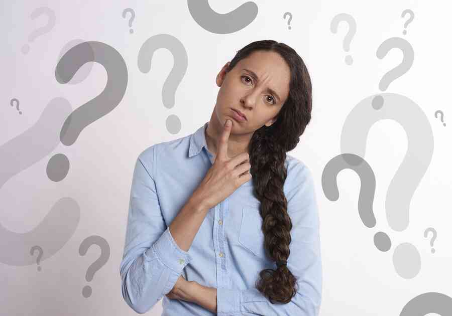 Confused woman surrounded by question marks