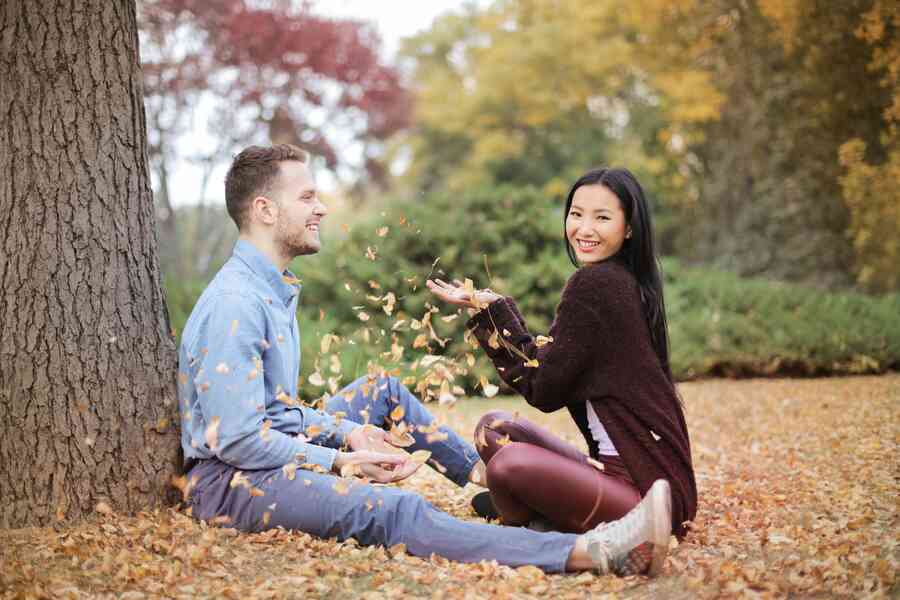 Happy couple scattering leaves in a park