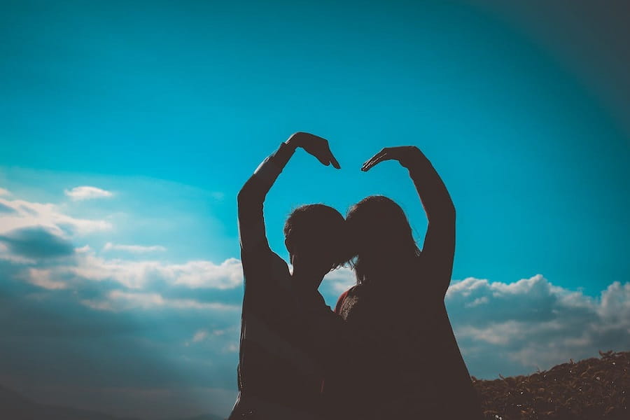 Silhouette of couple above clouds