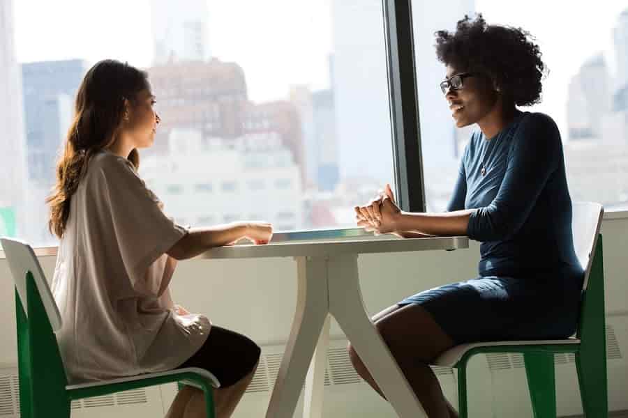 Two women beside window talking