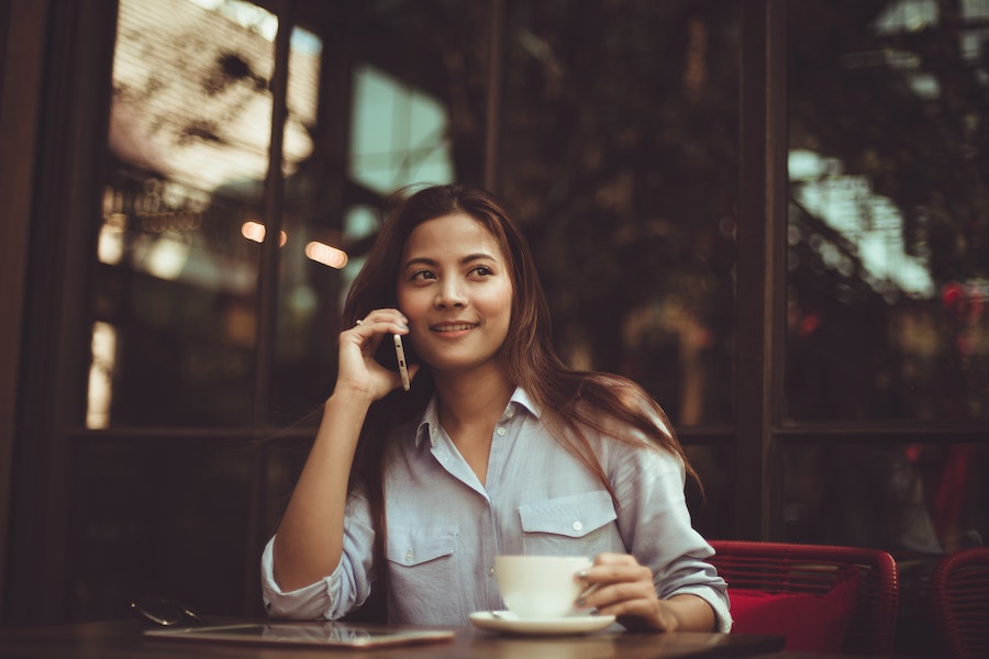 Woman using phone in a café