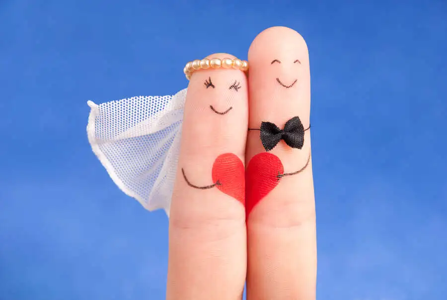 Marriage of happy couple shown as two fingers